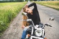 Attractive biker girl looks in a rear view mirror of her motorcycle Royalty Free Stock Photo