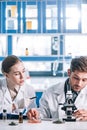 attractive biochemist looking at coworker near Royalty Free Stock Photo