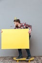 Attractive birthday man on skateboard holding copyspace board