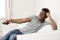 Attractive black african american man sitting at home sofa couch watching television Royalty Free Stock Photo