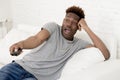 Attractive black african american man sitting at home sofa couch watching television Royalty Free Stock Photo