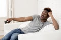 Attractive black african american man sitting at home sofa couch watching television Royalty Free Stock Photo