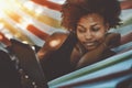 Attractive black cirly girl with digital tablet in hammock Royalty Free Stock Photo