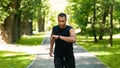 Attractive black guy looking at his fitness tracker while jogging at park Royalty Free Stock Photo