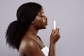 Attractive Black Woman Holding Hygienic Lip Balm In Hand Over Gray Background Royalty Free Stock Photo