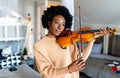 Attractive young african american woman musician plays the violin practicing musical instrument Royalty Free Stock Photo