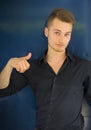 Attractive blond, blue eyed young man smiling and doing thumb up sign Royalty Free Stock Photo