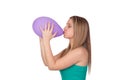 Attractive blond girl swelling a purple balloon