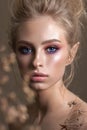 Attractive blond model with a curl hairstyle, colorful smoky eyes and perfect glossy skin. Close up portrait.
