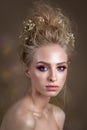 Attractive blond model with a volume curl hairstyle, colorful smoky eyes and perfect skin