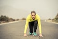 Attractive blond sport woman ready to start running practice training race starting on asphalt road mountain landscape Royalty Free Stock Photo