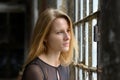 Attractive blond student looking out of a window Royalty Free Stock Photo