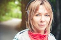 Attractive blond woman in the forest. Close-up portrait of a sporty smiling girl listening to music Royalty Free Stock Photo