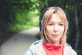 Attractive blond woman in the forest. Close-up portrait of a sporty smiling girl listening to music Royalty Free Stock Photo