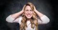 Attractive blond woman is indignant and angry on a dark background.