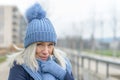 Attractive blond woman snuggling into a warm scarf Royalty Free Stock Photo