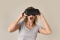 Attractive blond woman wearing headset VR virtual reality vision goggles watching video Royalty Free Stock Photo