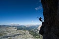 Attractive blonde female climber in silhouette on a steep Via Ferrata pointing to the sky Royalty Free Stock Photo