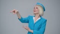 Attractive blonde flight attendant launches a paper airplane.