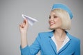 Attractive blonde flight attendant launches a paper airplane.