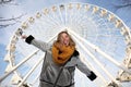 Attractive blonde girl looking for an adventure on a ferris wheel round attraction. Happy positive mood