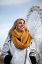 Attractive blonde girl looking for an adventure on a ferris wheel round attraction. Happy positive mood