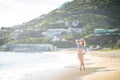 Attractive blonde girl walking on the beach, fit sporty healthy sexy body in bikini, woman enjoys sun, freedom, vacation Royalty Free Stock Photo