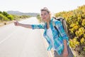 Attractive blonde hitch hiking on rural road