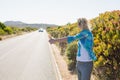 Attractive blonde hitch hiking on rural road