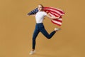 Attractive blonde made a jump with an American flag. photo shoot in the studio on a yellow background Royalty Free Stock Photo