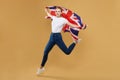 Attractive blonde made a jump with a British flag. photo shoot in the studio with a yellow background Royalty Free Stock Photo