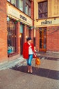 Attractive blonde in a red coat walks around the city