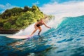 Attractive surf girl riding on surfboard in ocean. Surfer on blue wave during surfing Royalty Free Stock Photo