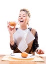 Attractive blonde woman with a napkin on her chest smiling and eating donut & happy smiling isolated on white back