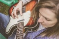 Attractive blonde woman playing a guitar outside in the countryside Royalty Free Stock Photo