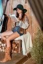 Attractive bohemian girl reading a book sitting on a bench in a