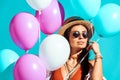 Attractive bohemian girl standing with helium balloons