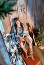 Attractive bohemian woman sitting on a bench in wooden house, guitar