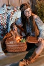 Attractive bohemian woman sitting on a floor with basket