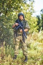 Attractive brave military woman with a gun in forest, survival in wild forest