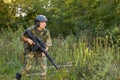 Attractive brave military woman with a gun in forest, survival in wild forest