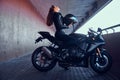 Attractive brave woman is sitting on her motobike in tunnel