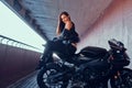 Attractive brave woman is sitting on her motobike in tunnel