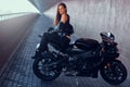 Attractive brave woman is sitting on her motobike in tunnel