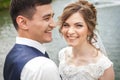 Attractive bride and groom smiling near the pond