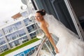 Attractive bride is standing on the balcony. Royalty Free Stock Photo