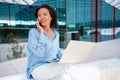 Attractive brunette businesswoman talking mobile phone with client. Pretty caucasian female business person smile when phone Royalty Free Stock Photo