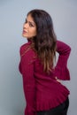 Attractive brunette dressed in red outfit smiling and confident. Studio photo