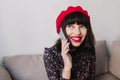 Attractive brunette girl with red lips in vintage clothes speaking with boyfriend by phone and smiling. Charming young Royalty Free Stock Photo