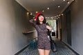 Attractive brunette girl with short hairstyle standing indoors carrying leather black bag and smiling widely. Charming Royalty Free Stock Photo